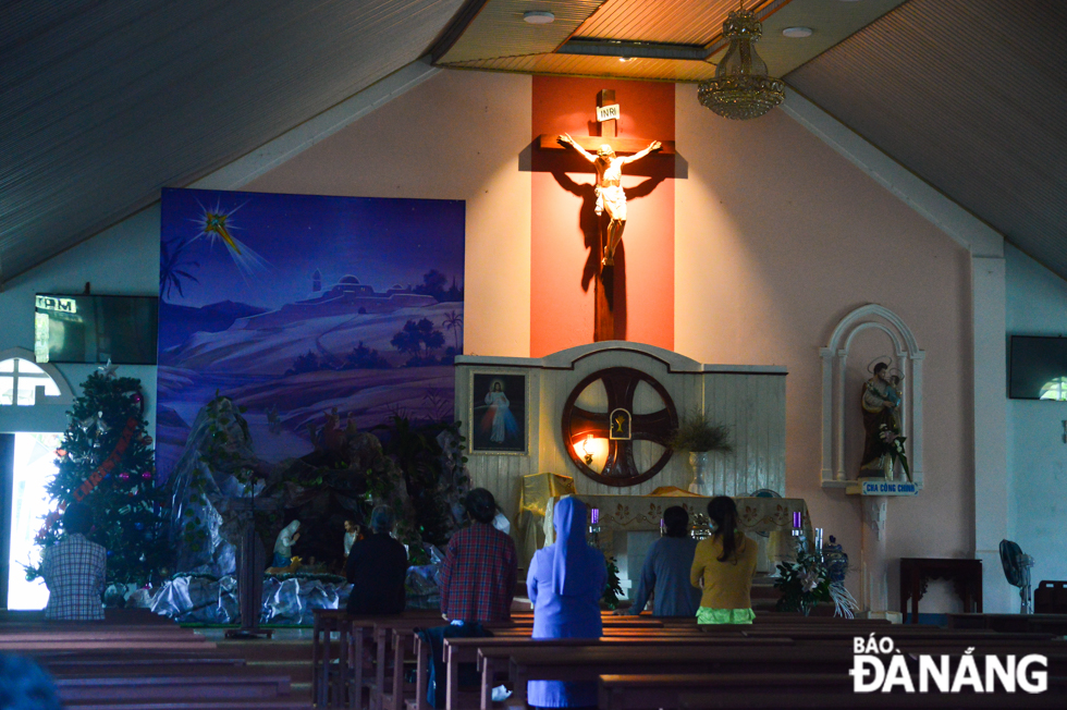 The parishioners limit large gatherings and keep a safe distance from others when praying in the church.