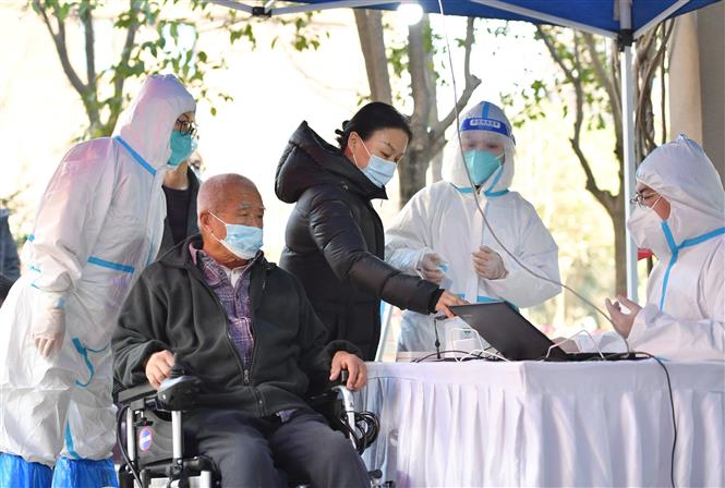 Nhân viên y tế lấy mẫu xét nghiệm COVID-19 cho người dân tại Tây An, tỉnh Thiểm Tây, Trung Quốc, ngày 21/12/2021. Ảnh: THX/TTXVN