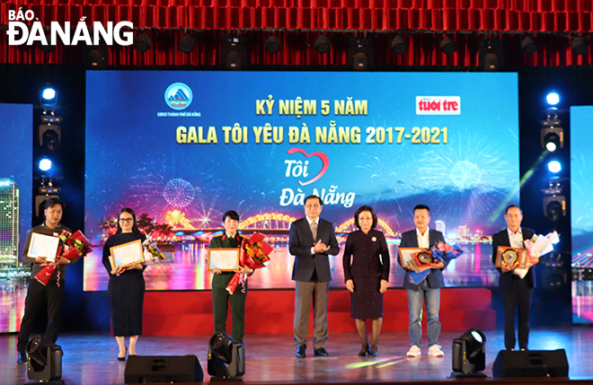 Vice Chairwoman of the Da Nang People's Committee Ngo Thi Kim Yen (third, right) and former municipal People's Committee Chairman Huynh Duc Tho (centre) giving medals and gifts to outstanding individuals who were honoured in the ‘I Love Da Nang’ gala night
