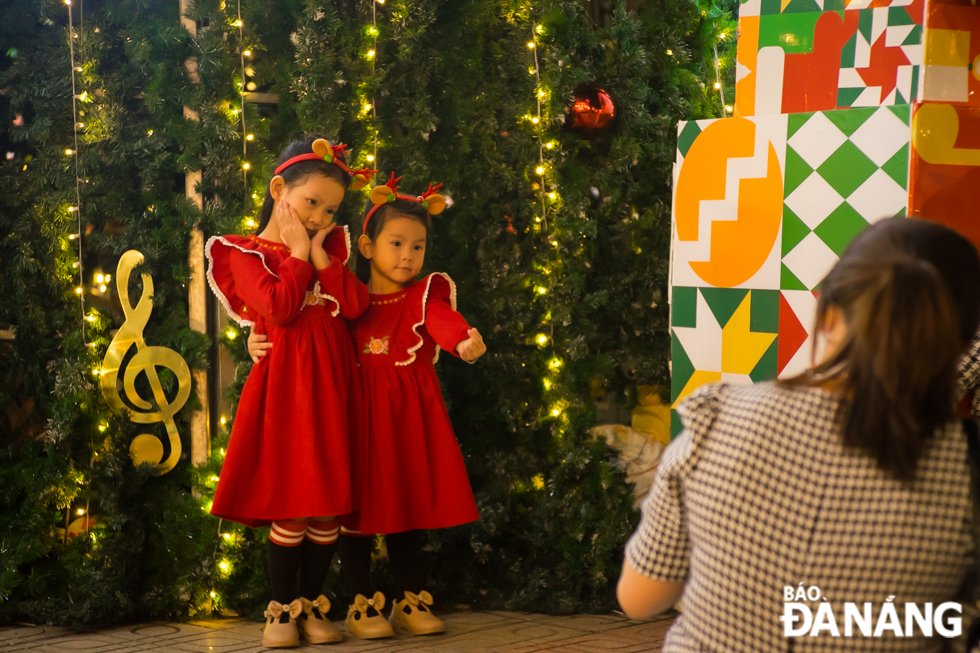 Two little girls posing for pictures in colorful Christmas dresses. Photo: NGUYEN LE