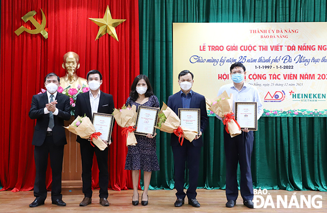 Editor-in-chief of the Da Nang Newspaper cum Head of the Jury Board Nguyen Duc Nam (first left) presenting flowers to the contest’s sponsors
