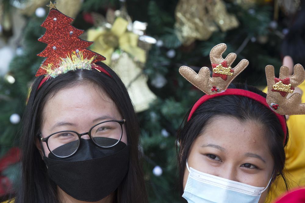 Hai cô gái đeo khẩu trang đứng chụp ảnh trước nhà thờ tại Bali, Indonesia ngày 24/12. Ảnh: AP