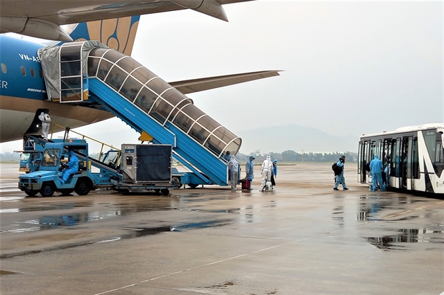 Passengers from a flight from the US left the plane and boarded the shuttle bus. — VNA/VNS Photo