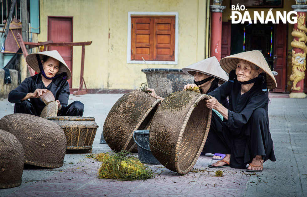   Elderly women use red silk rope to rub cow dung into baskets, according to the traditional method, so that when the oil is applied, the basket's shell can be tight and not leak.