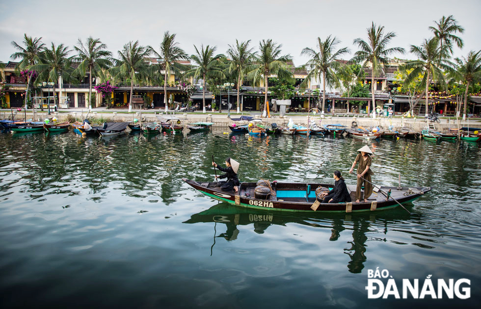 Recreating the scene of the people of Man Thai fishing village bringing pairs of gourds containing fish sauce to Hoi An for sale.