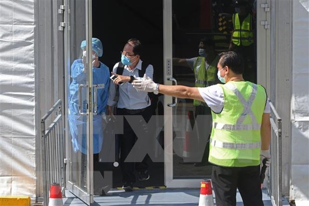A passenger from Johor, Malaysia, via the land Vaccinated Travel Lane (VTL) leaves after getting negative test results for the antigen rapid test (ART) at Singapore's Queen Street bus terminal in November 2021. (Photo:Xinhua/VNA)