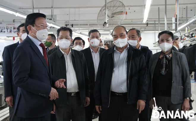 State President Nguyen Xuan Phuc (second, right), Da Nang Party Committee Secretary Nguyen Van Quang (second, left), and some of the city leaders visiting the company’s production workshop