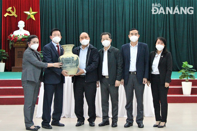 State President Nguyen Xuan Phuc (fourth, right), Da Nang Party Committee Secretary Nguyen Van Quang (third, right) and Da Nang People's Committee Chairman Le Trung Chinh (second, right) presenting a souvenir gift to the company’s leaders.