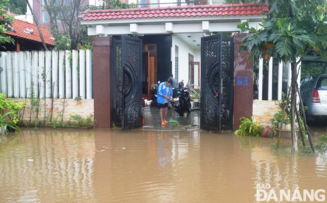 A household on Luong Huu Khanh Street is cleaning up its yard after flooding.