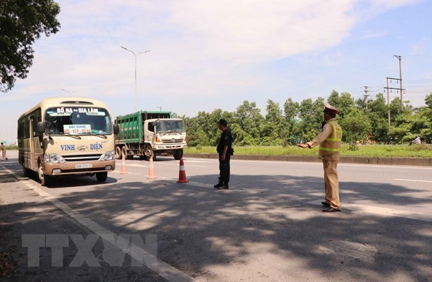 Cảnh sát giao thông kiểm tra các phương tiện vi phạm. (Ảnh: TTXVN)