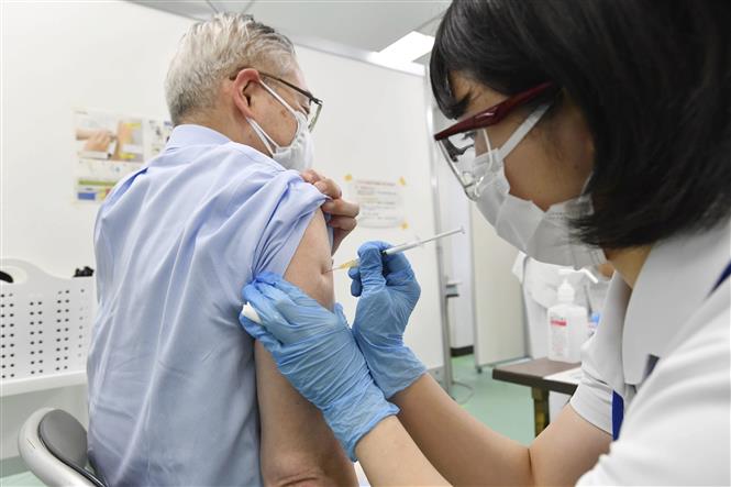 Nhân viên y tế tiêm vaccine phòng COVID-19 cho người dân tại Tokyo, Nhật Bản ngày 30/10/2021. Ảnh: Kyodo/TTXVN