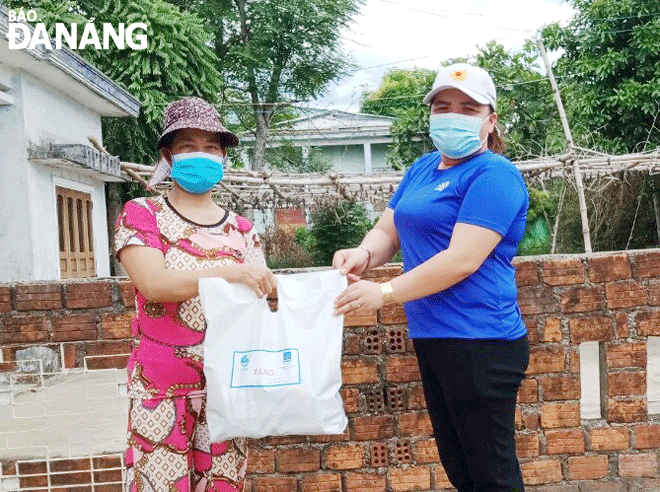 Chị Nguyễn Thị Yến (phải) tặng quà cho hội viên phụ nữ bị ảnh hưởng dịch bệnh tại thôn Thạch Bồ, xã Hòa Tiến, huyện Hòa Vang. Ảnh: PHƯƠNG TẤN	