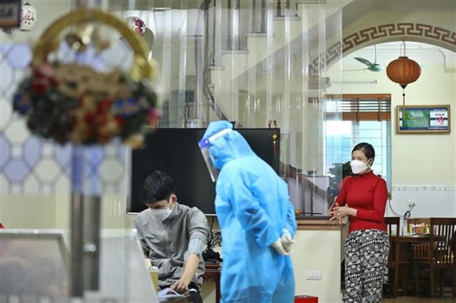 Health staff examine a home-treating COVID-19 patient in Thanh Trì District, Hà Nội. VNA/VNS Photo