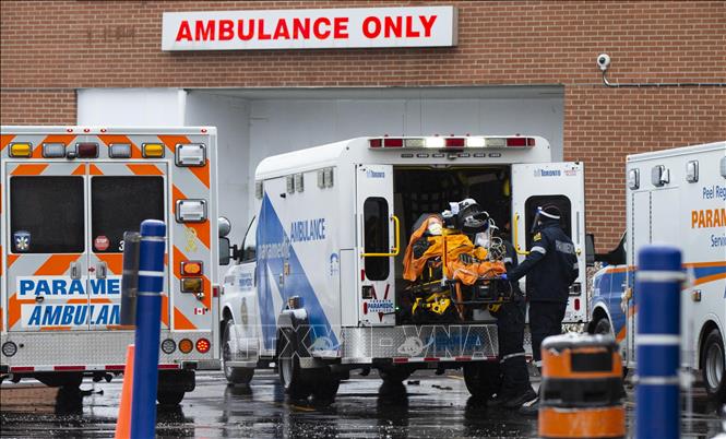 Nhân viên y tế chuyển bệnh nhân COVID-19 tới bệnh viện tại Mississauga, Ontario, Canada, ngày 27/12/2021. Ảnh: THX/TTXVN