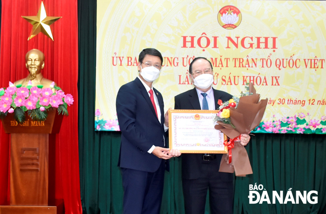 Chủ tịch Ủy ban MTTQ Việt Nam thành phố Ngô Xuân Thắng (trái) trao tặng Huân chương “Đại đoàn kết dân tộc” cho ông Nguyễn Ngọc Minh. Ảnh: VĂN SUM