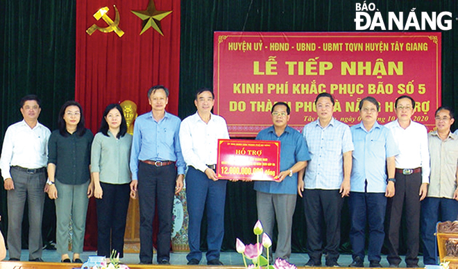 Chủ tịch UBND thành phố Lê Trung Chinh (thứ 5, trái sang) đến thăm, tặng quà cho nhân dân huyện Tây Giang (tỉnh Quảng Nam) và trao số tiền hỗ trợ 12 tỷ đồng từ Quỹ phòng chống thiên tai thành phố. Ảnh: P.V