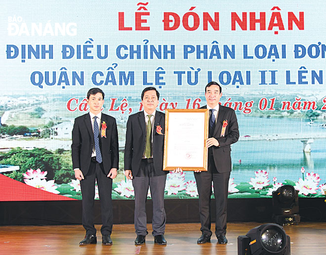 Chủ tịch UBND thành phố Lê Trung Chinh (bên phải) trao quyết định của Bộ Nội vụ về điều chỉnh phân loại đơn vị hành chính quận từ loại 2 lên loại 1 cho quận Cẩm Lệ. Ảnh: TRỌNG HÙNG