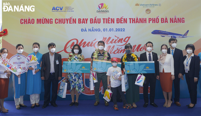 Những vị khách may mắn đầu tiên trên chuyến bay được chào mừng và nhận quà tặng trong ngày đầu năm mới. Ảnh:THU HÀ.