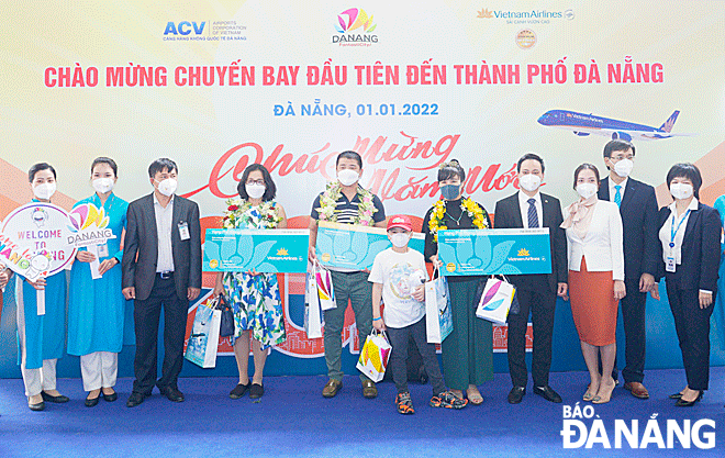 Hành khách trên chuyến bay đầu năm mới đến Đà Nẵng nhận quà của hãng hàng không Quốc gia Việt Nam. Ảnh: THU HÀ