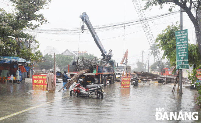 Việc thi công công trình nút giao thông phía tây cầu Trần Thị Lý gây ngập một đoạn trên tuyến đường Núi Thành sau mưa lớn (Ảnh chụp ngày 28-12-2021). Ảnh: HOÀNG HIỆP