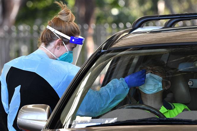  Nhân viên y tế lấy mẫu xét nghiệm Covid-19 cho người dân tại Sydney, Australia. Ảnh: AFP/TTXVN