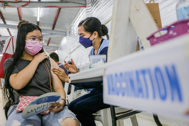A girl gets vaccinated against COVID-19 in Marikina city, the Philippines, on November 29, 2021 (Photo: Xinhua/VNA)