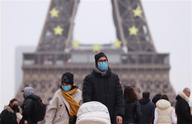 Người dân đeo khẩu trang phòng COVID-19 khi đi trên đường phố Paris, Pháp ngày 29/12/2021. Ảnh: THX/TTXVN