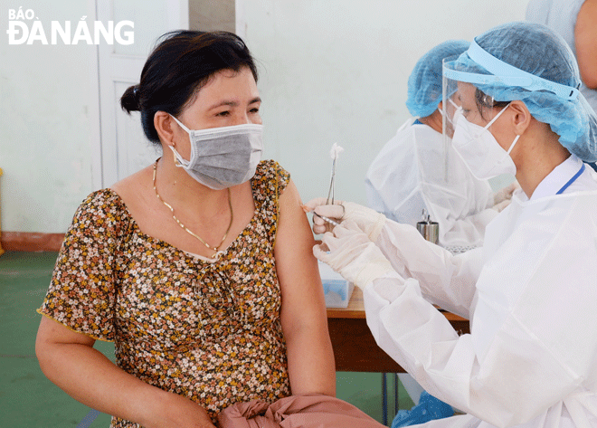 A healthcare professional giving a booster vaccination to a woman in Son Tra District. Photo: PHAN CHUNG