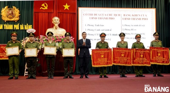 Chủ tịch UBND thành phố Lê Trung Chinh (giữa) trao Cờ thi đua và Bằng khen cho các tập thể có thành tích xuất sắc. Ảnh: LÊ HÙNG