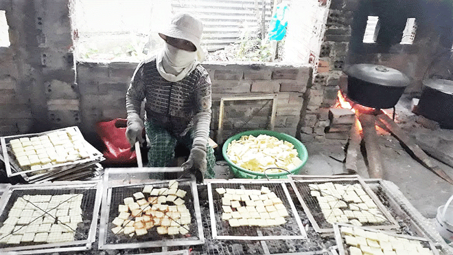 Công đoạn nướng bánh bằng than củi ở lò bánh khô mè Bà Nghĩ. (Ảnh: Nhân vật cung cấp)