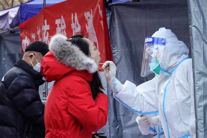 Nhân viên y tế lấy mẫu xét nghiệm COVID-19 cho người dân tại Tây An, tỉnh Thiểm Tây, Trung Quốc. Ảnh: THX/TTXVN