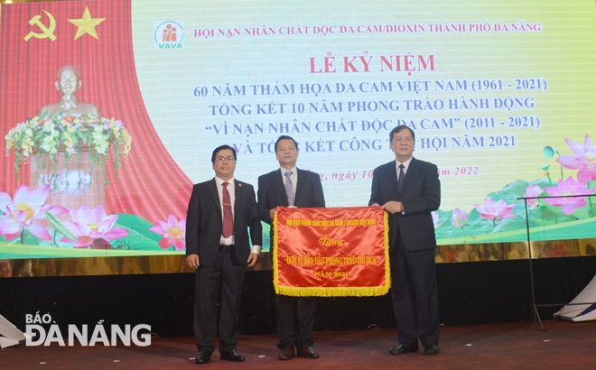 Vice Chairman of the Central Committee of Viet Nam Association of Victims of Agent Orange/Dioxin Nguyen Van Khanh (first right) presenting an emulation flag to DAVA representatives. Photo: LE VAN THOM