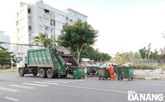 Công nhân Công ty CP Môi trường đô thị Đà Nẵng đang thu gom rác sinh hoạt trên địa bàn quận Sơn Trà. Ảnh: HOÀNG HIỆP