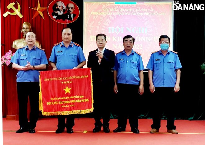 Thừa ủy quyền của Thủ tướng Chính phủ, Bí thư Thành ủy Nguyễn Văn Quảng (giữa) trao Cơ thi đua cho VKSND thành phố. Ảnh: LÊ HÙNG