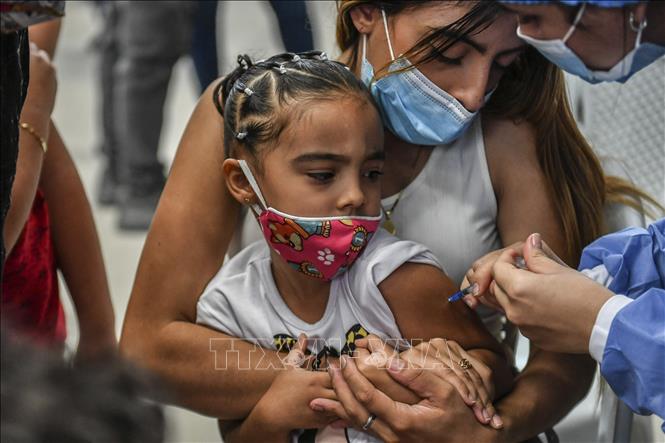 Nhân viên y tế tiêm vaccine COVID-19 cho trẻ em tại Medellin, Colombia, ngày 14/12/2021. Ảnh: AFP/TTXVN