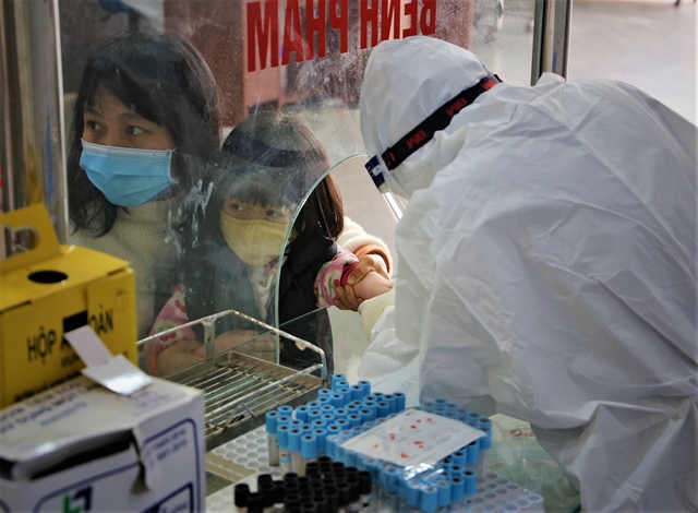 A health worker collects specimens from a young child infected with coronavirus in the northern province of Bắc Giang. — VNA/VNS Photo 