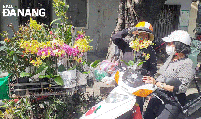 “Cửa hàng hoa di động” của chị Trần Thị Kim Vinh nổi bật giữa phố thị. Ảnh: NHƯ HẠNH