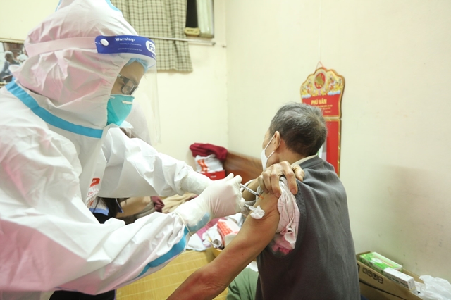 A medical worker gives a COVID-19 injection to an elderly person at home in Cửa Đông Ward, Hoàn Kiếm District in Hà Nội. — VNA/VNS Photo Minh Quyết