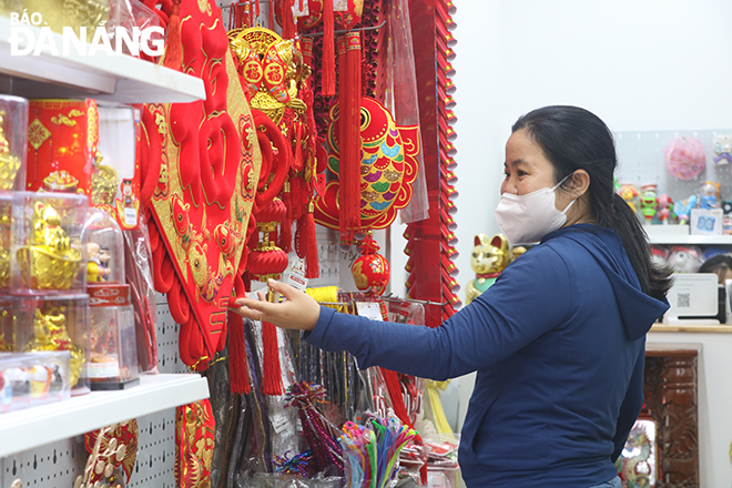 A resident is shopping for Tet decorations. Photo: MAI QUE