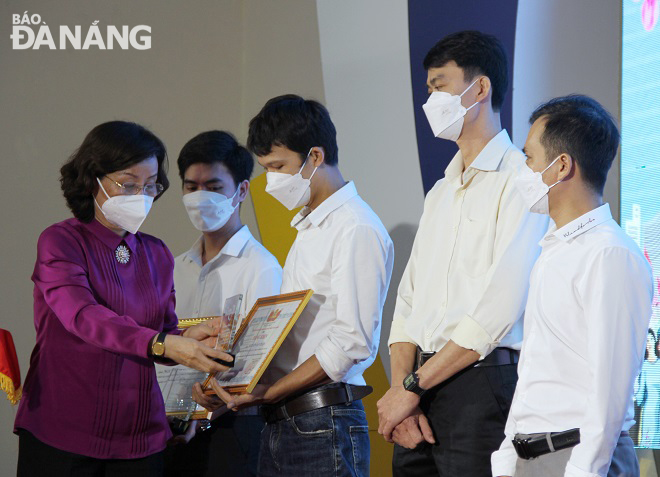 Phó Chủ tịch UBND thành phố Ngô Thị Kim Yến (bìa trái) tặng bằng khen và biểu trưng cảm ơn người lao động năm 2021. Ảnh: L.P