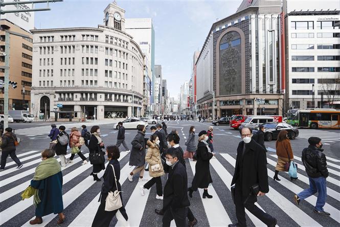 Người dân đeo khẩu trang phòng dịch COVID-19 khi di chuyển trên đường phố Tokyo, Nhật Bản, ngày 17/1/2022. Ảnh: Kyodo/TTXVN