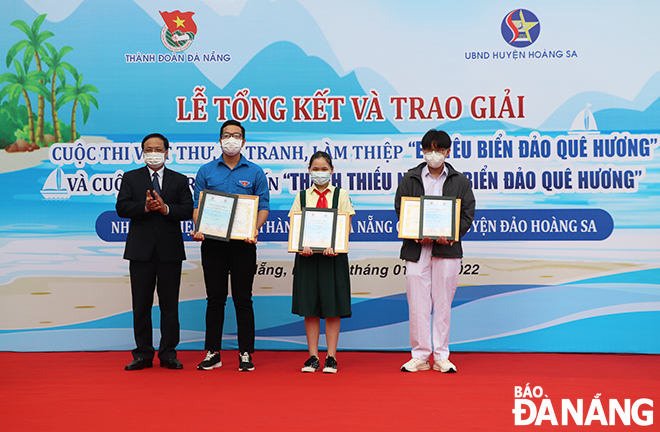 Director of the Da Nang Department of Home Affairs cum Chairman of Hoang Sa Islands District People's Committee Vo Ngoc Dong (left, first) awards the first prizes to the winning entrants at the online contest ‘Children and teenagers with love for the homeland’s sea and islands’. Photo: XUAN DUNG