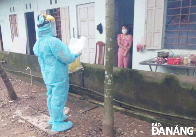 Một bệnh nhân mắc Covid-19 trên địa bàn huyện Hòa Vang được nhân viên y tế hướng dẫn theo dõi, điều trị tại nhà. Ảnh: PHAN CHUNG