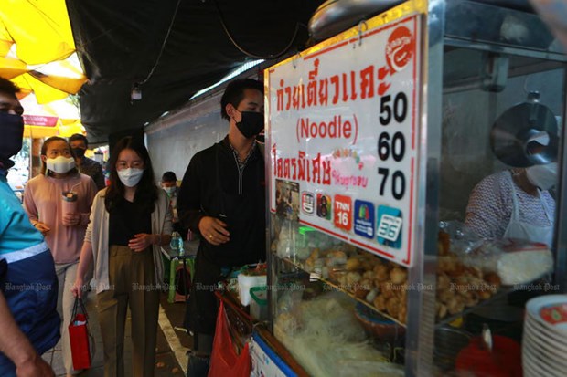 People queue for noodle soup at a shop in Silom that displays increased prices. (Photo:  www.bangkokpost.com)