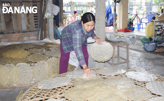 After coming out of the oven, rice paper is dried on charcoal to retain its characteristic flavour and crispiness. Photo: D.H.L