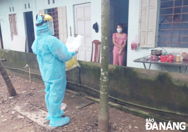 A healthcare worker is giving medical advice on how to recover at home to a COVID-19 patient in Hoa Vang District. Photo: PHAN CHUNG