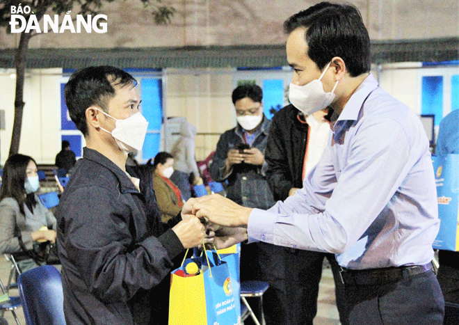 Chủ tịch Liên đoàn Lao động thành phố Nguyễn Duy Minh (phải) trao quà Tết cho công nhân làm việc tại Khu công nghiệp Hòa Khánh. Ảnh: LAM PHƯƠNG	
