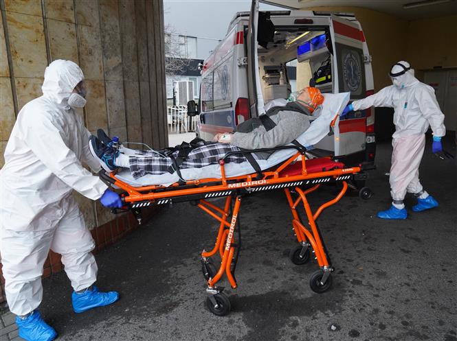 Nhân viên y tế chuyển bệnh nhân COVID-19 vào bệnh viện ở Vácsava, Ba Lan. Ảnh: AFP/TTXVN