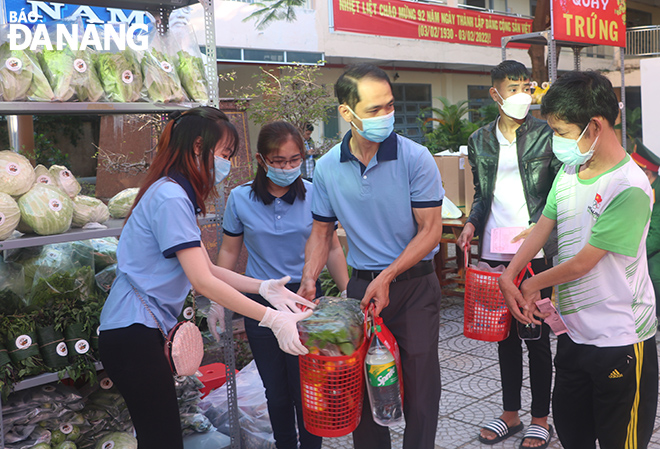 Lực lượng phường Phước Ninh hỗ trợ cho người dân tham gia phiên chợ 