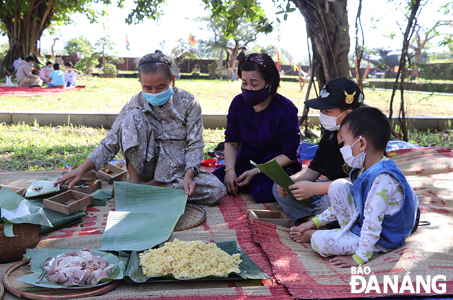 Elderly and child visitors learn to make 'banh chung'.